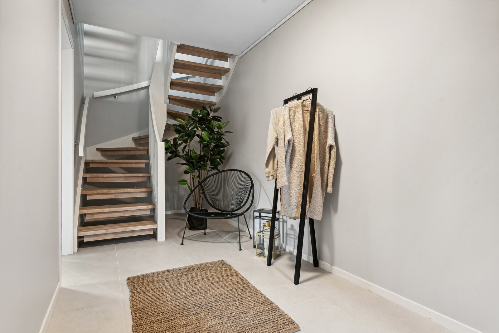 Gangen har fliser med gulvvarme og det er lagringsplass under trapp. Galleribilde