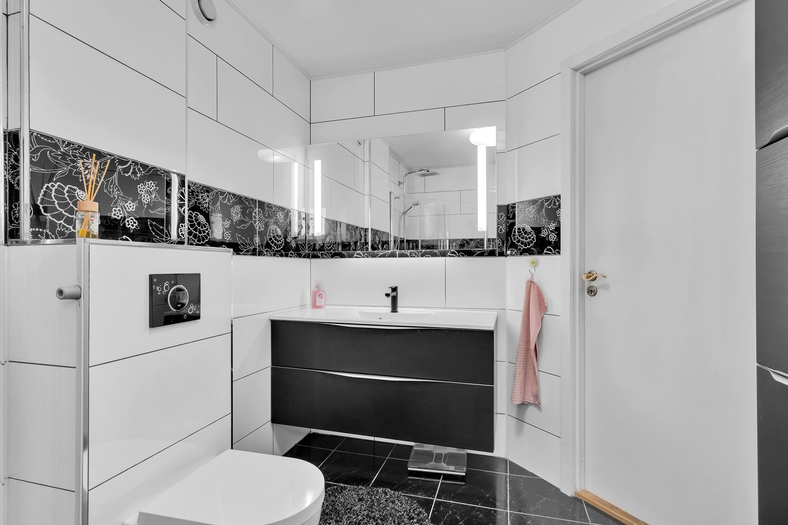 Badet har vegghengt toalett og servant med skuffeseksjon Galleribilde