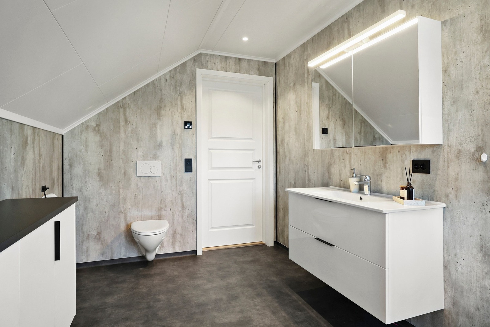 Badet inneholder også vegghengt baderomsmøbel, dusjkabinett og vegghengt toalett. Galleribilde