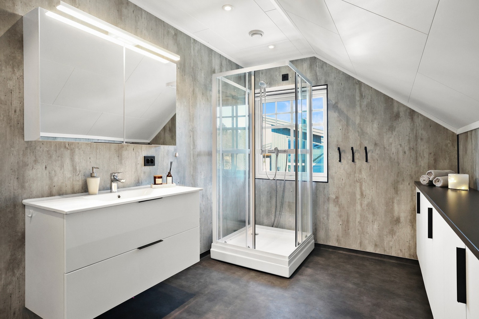Badet har gulvbelegg med gulvvarme og vegghengt servantinnredning med speilskap med overlys. Galleribilde