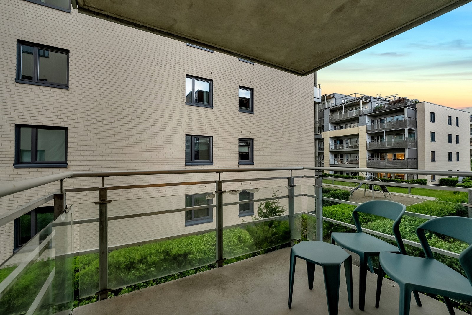 Balkongen er overbygd og har rekkverk av stål og glass Galleribilde