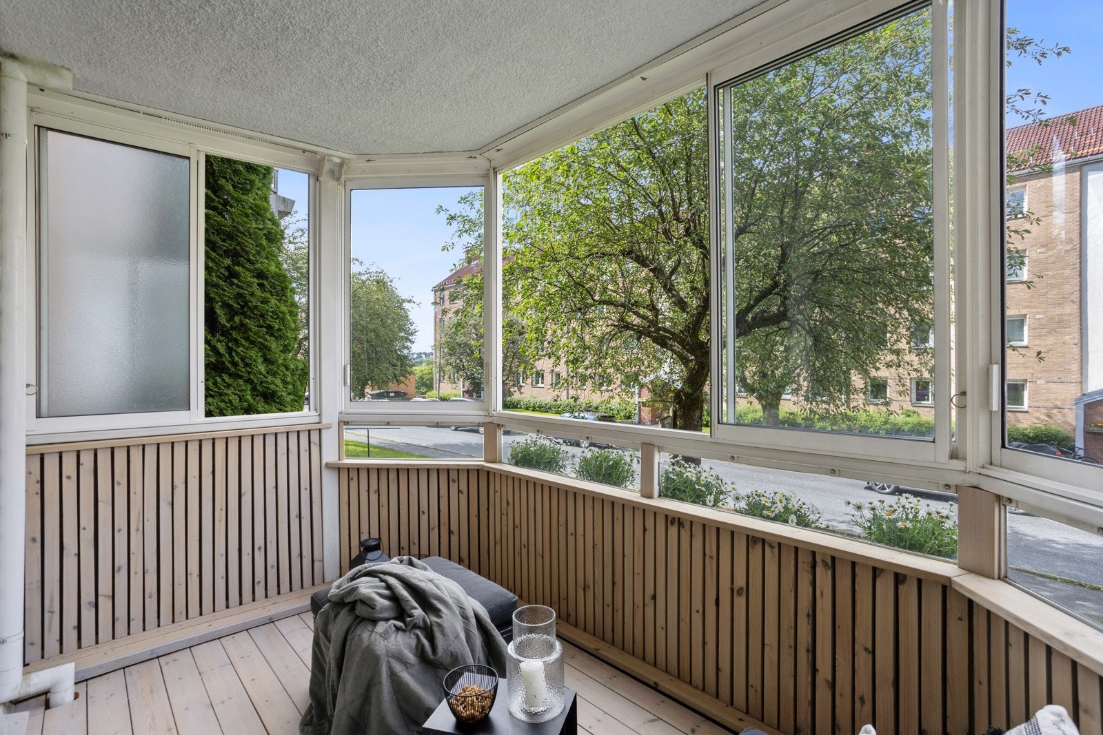Balkong med beiset tregulv og isolert brystningsvegg. God plass til utemøbler, grill og planter. Galleribilde