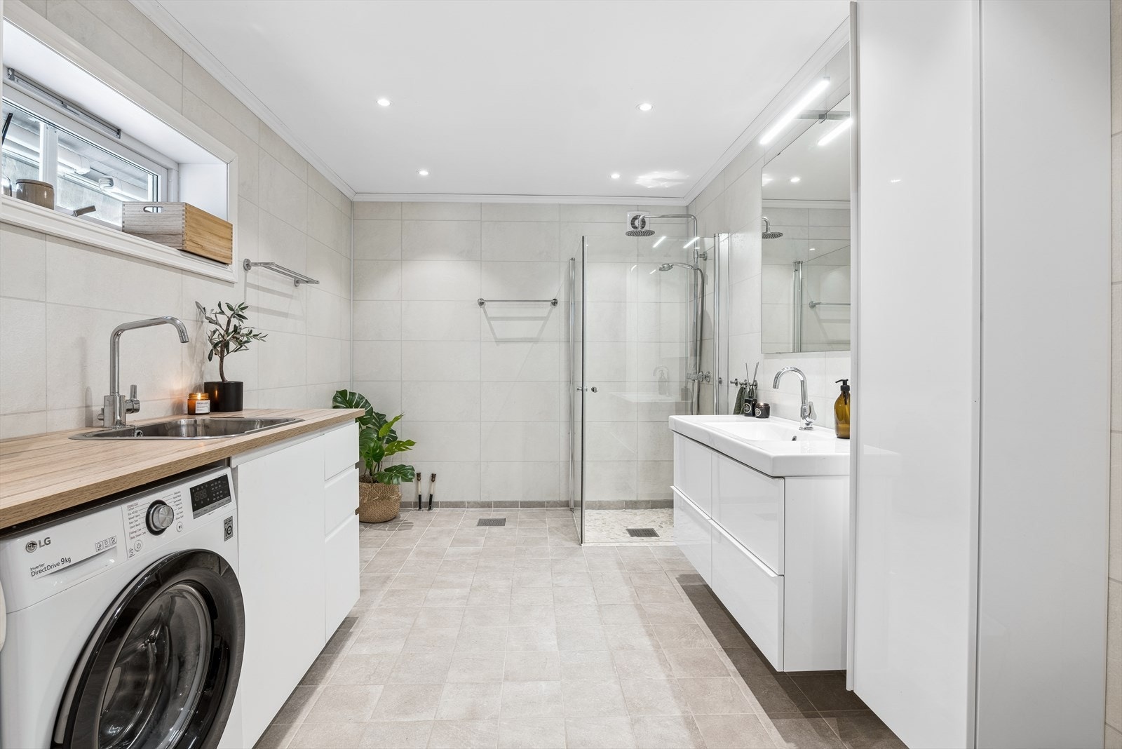 Lekkert og tidløst bad/vaskerom i 1. etg som ble oppgradert i 2016. Rommet har flislagt gulv på betong og elektriske varmekabler. Vegger med baderomspanel. Galleribilde