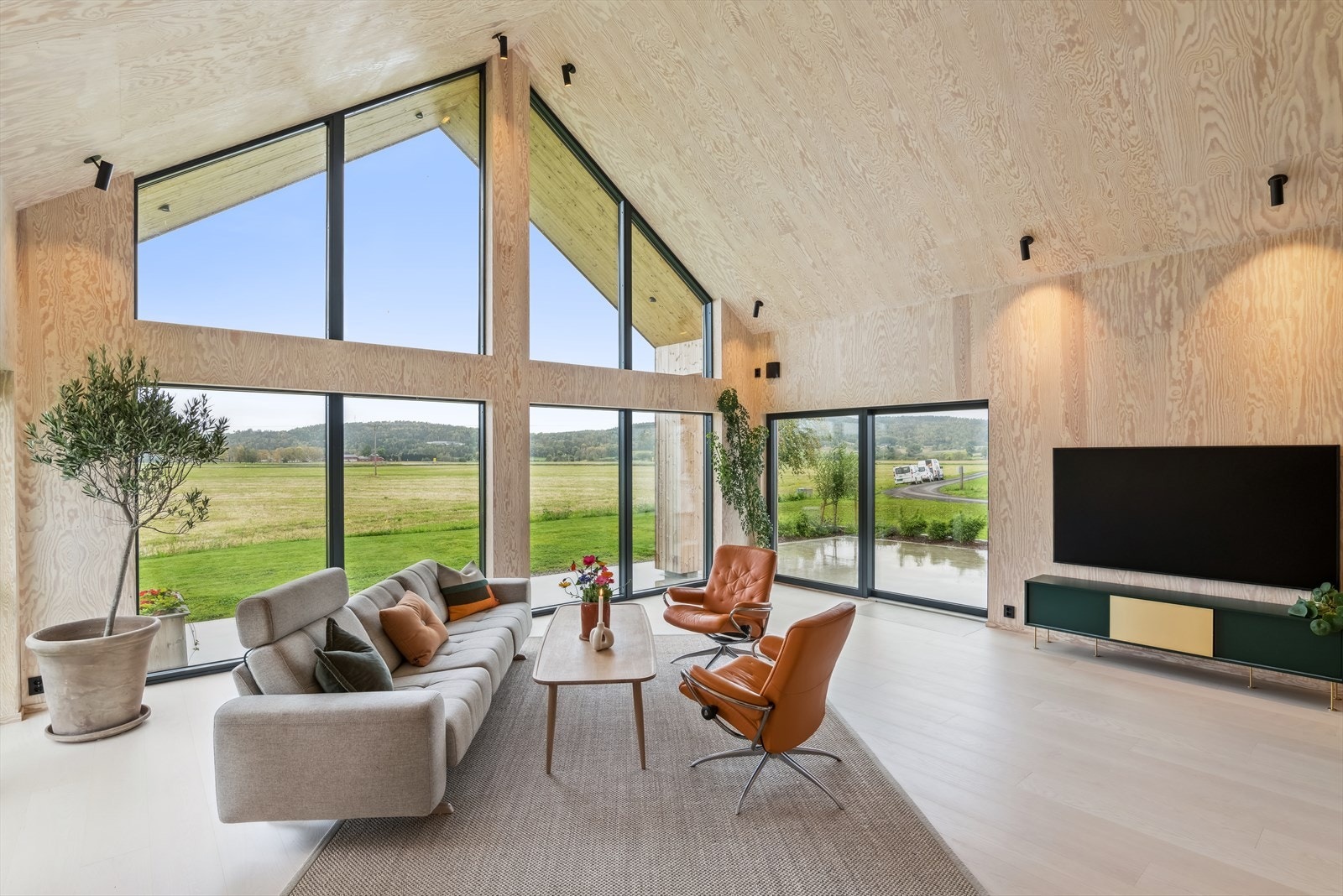 Stuen i tilbygget er helt unik med sin enorme takhøyde og store vinduer - her får du følelsen av å få naturen inn i stuen! Galleribilde