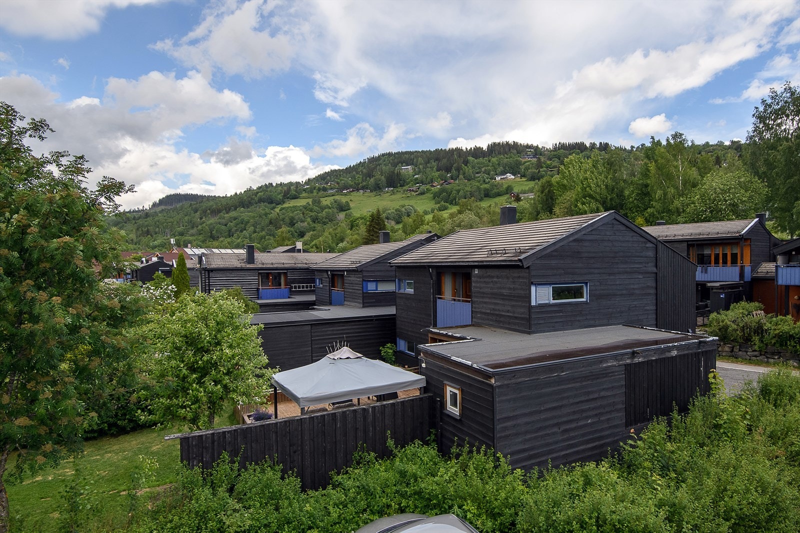 Boligen er bebygd over to plan og har en sammenhengende carport. Galleribilde