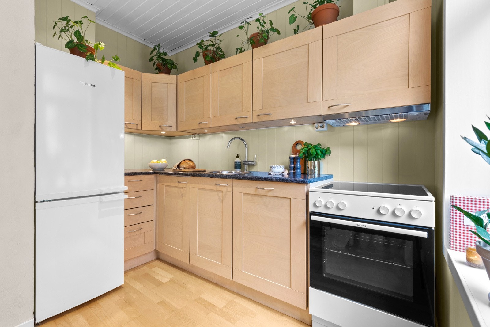 Kjøkkenet har velholdt innredning med profilerte fronter i heltre/finer og laminat benkeplate Galleribilde