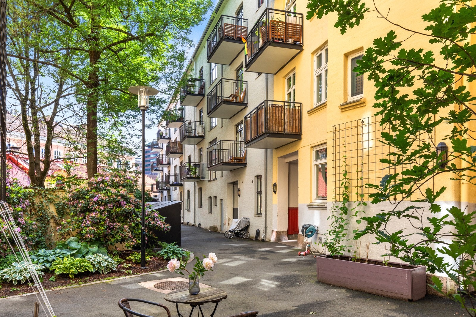 Borettslaget har flott felles bakgård med frodige blomsterbed og plass for sykkelparkering Galleribilde