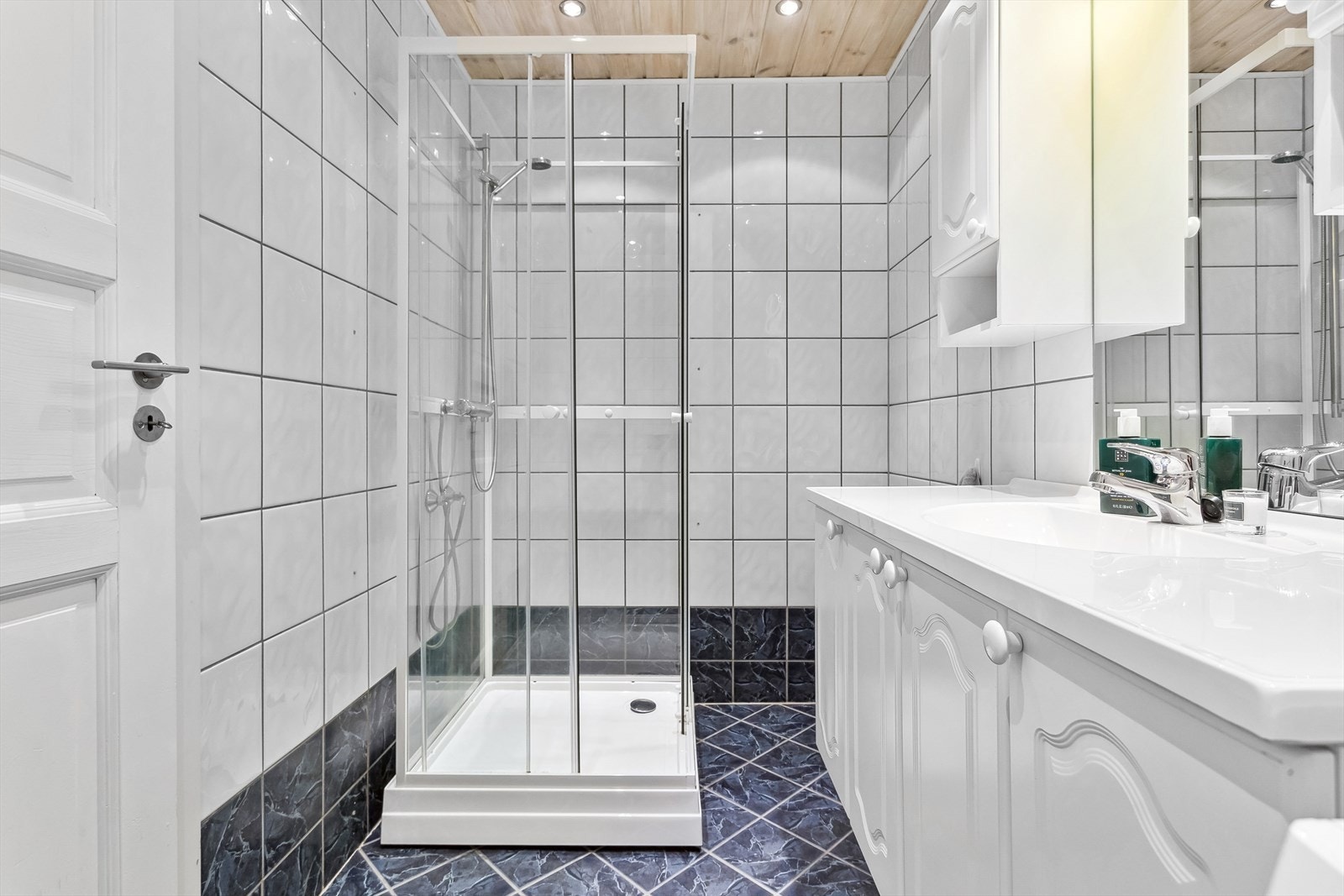 Innredet med servant med skap og speil, dusjkabinett og opplegg for vaskemaskin. Galleribilde