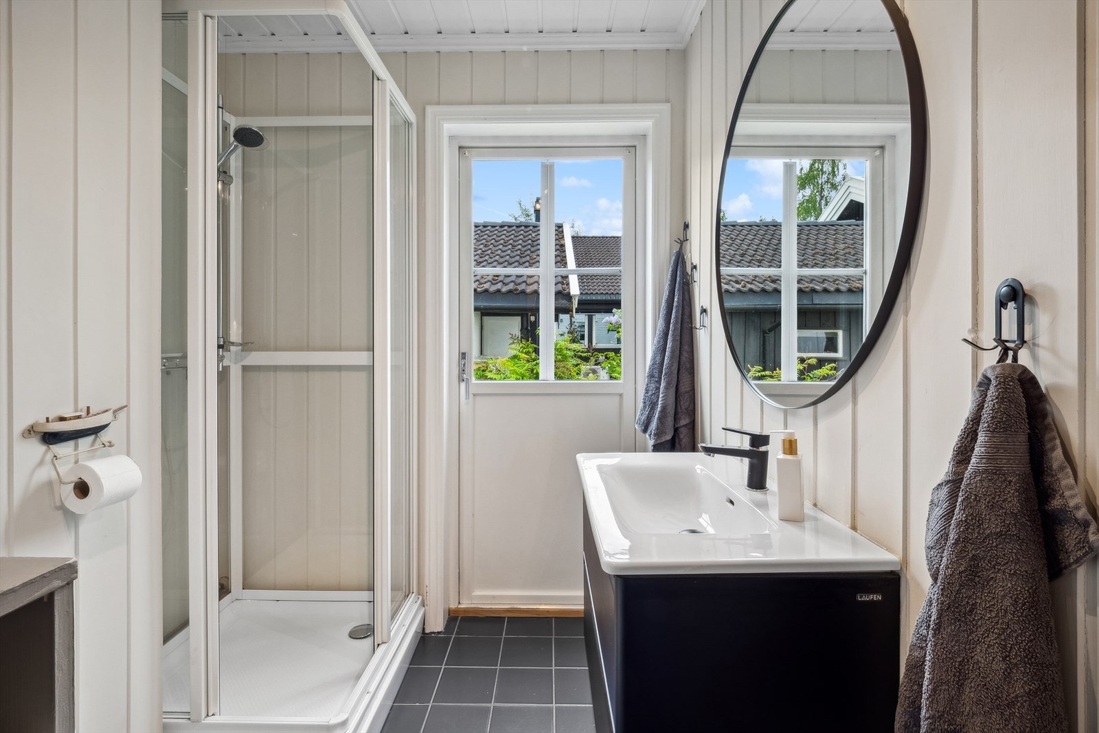 1.etasje: Kombinert vaskerom/bad. Rommet har panel på vegger og flislagt gulv. Rommet er utstyrt med servant, speil, toalett, dusjkabinett og det er opplegg for vaskemaskin. Galleribilde