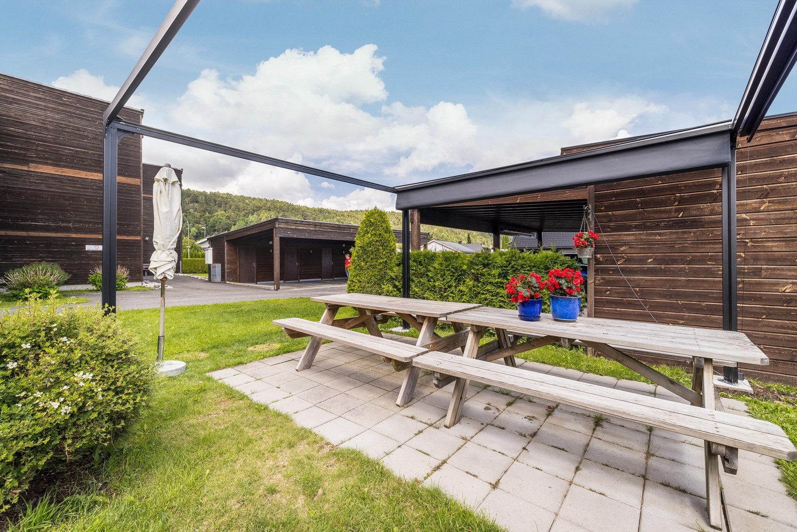 Ved gårdsplassen er det opparbeidet en fellessone med steinheller hvor det er sittebenker og det er satt opp en pergola i 2024, som gir økte bruksmuligheter for fellesplassen. Galleribilde