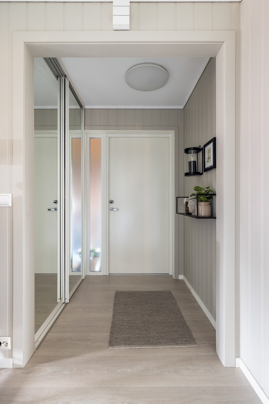 Det er pen en-stavs laminat på gulv, malt MDF Smart panel malt i dus, lys fargetone på vegger og hvitmalt, glatt himling. Overflatene er gjennomgående til stue og kjøkken, som gir en fin helhet til boligen. Galleribilde