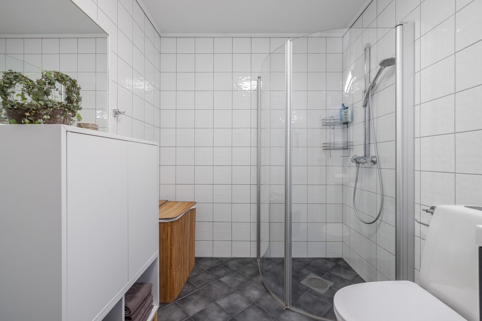 Pen dusjnisje med armatur på vegg og innfellbare dusjdører fra 2016, som er plassbesparende. Galleribilde