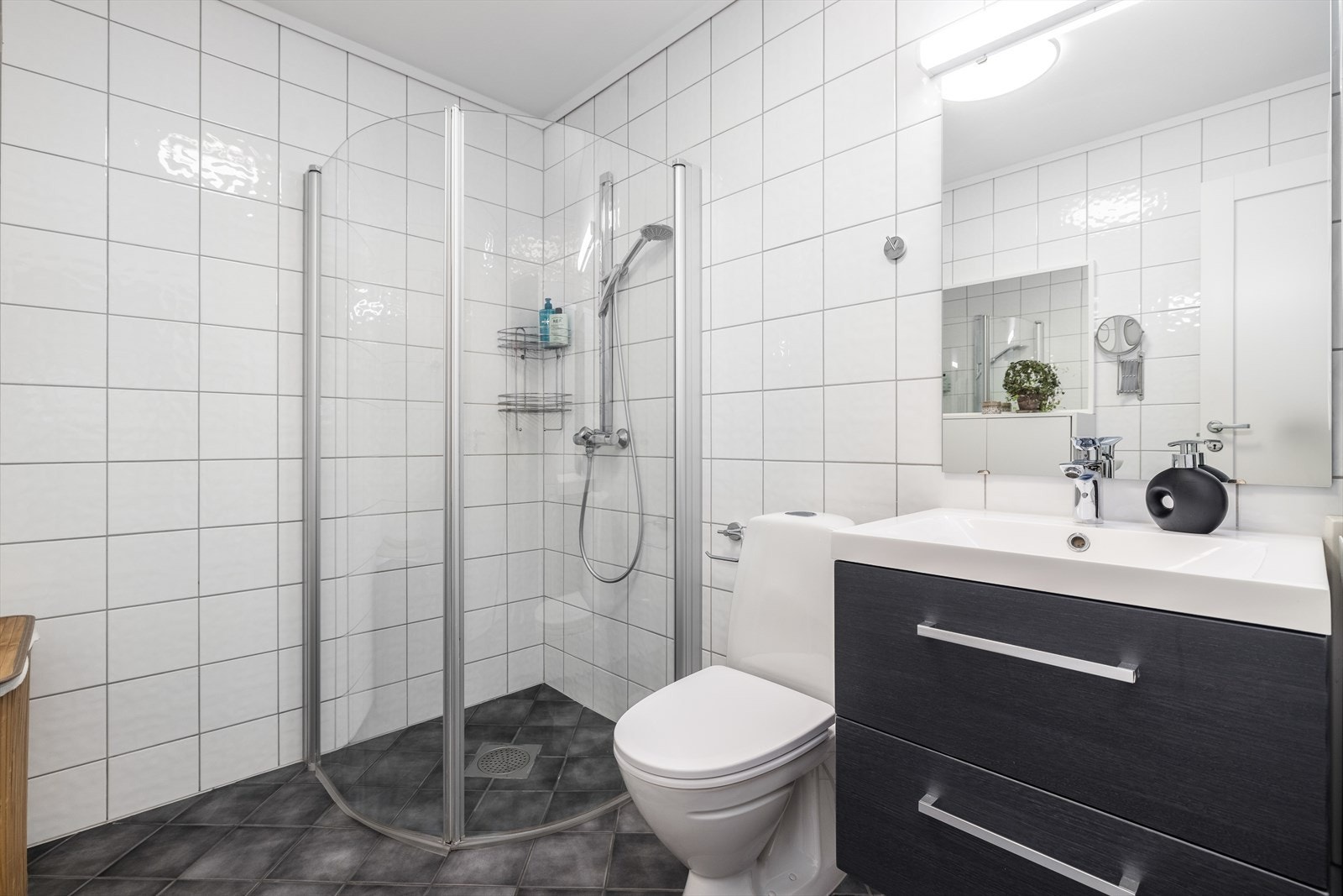 Pent, flislagt baderom fra byggeår, 2010, som er påkostet i 2020 med nytt møblement, gulvmontert toalett, speilflate og overlys. Galleribilde