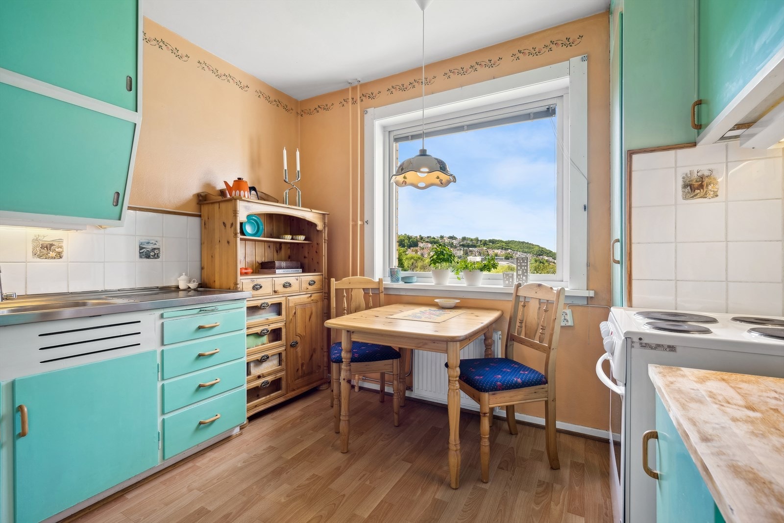 Kjøkkenet er av eldre, men sjarmerende standard. Med dagens løsning er det fin plass til et lite kjøkkenbord ved vinduet. Galleribilde