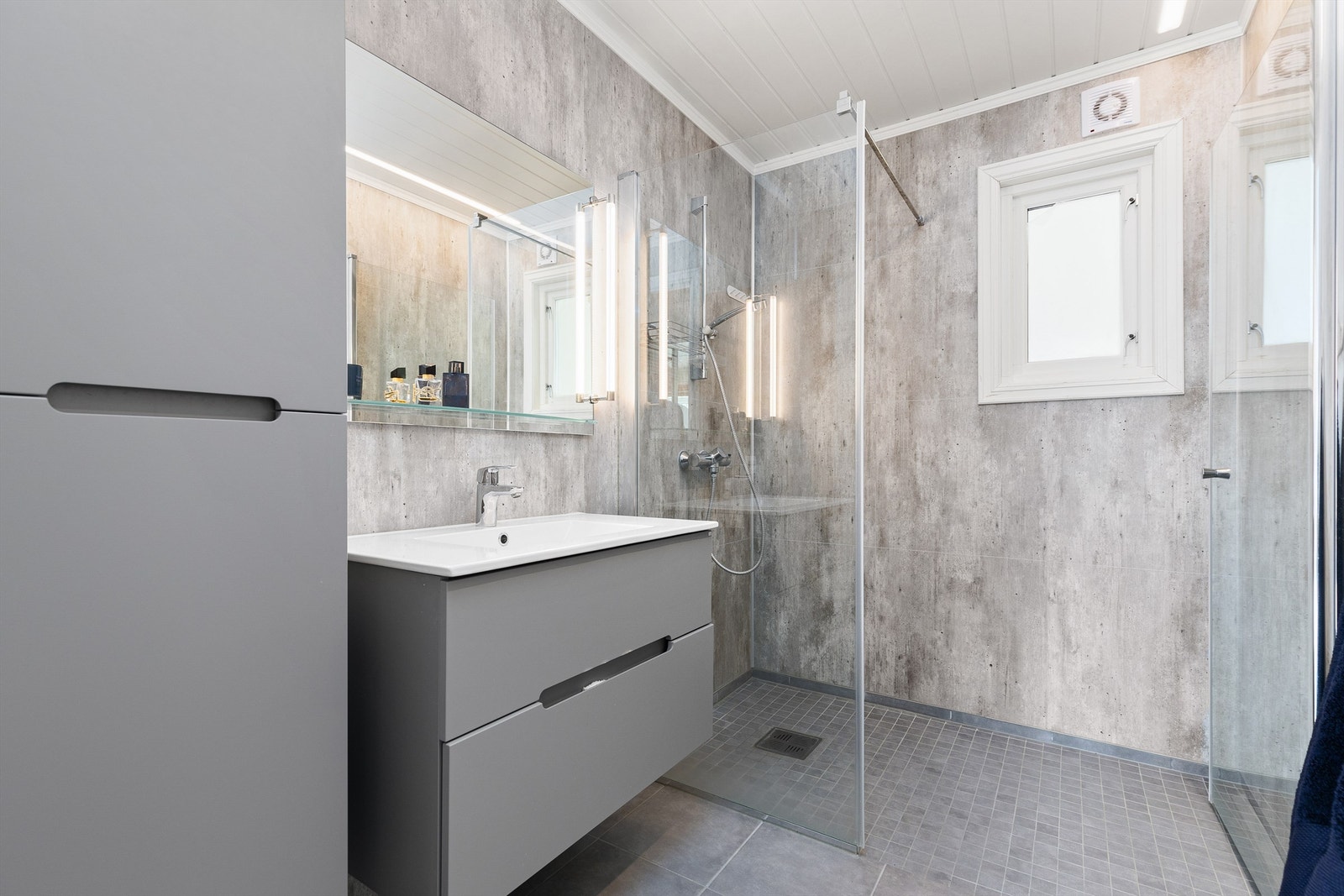 Pent bad på 4 kvm oppgradert i 2021 med flislagt gulv med varme og baderomspanel på vegger. Videre er badet utstyrt med servantskap med sideskap og speil med lys samt dusjhjørne. Galleribilde