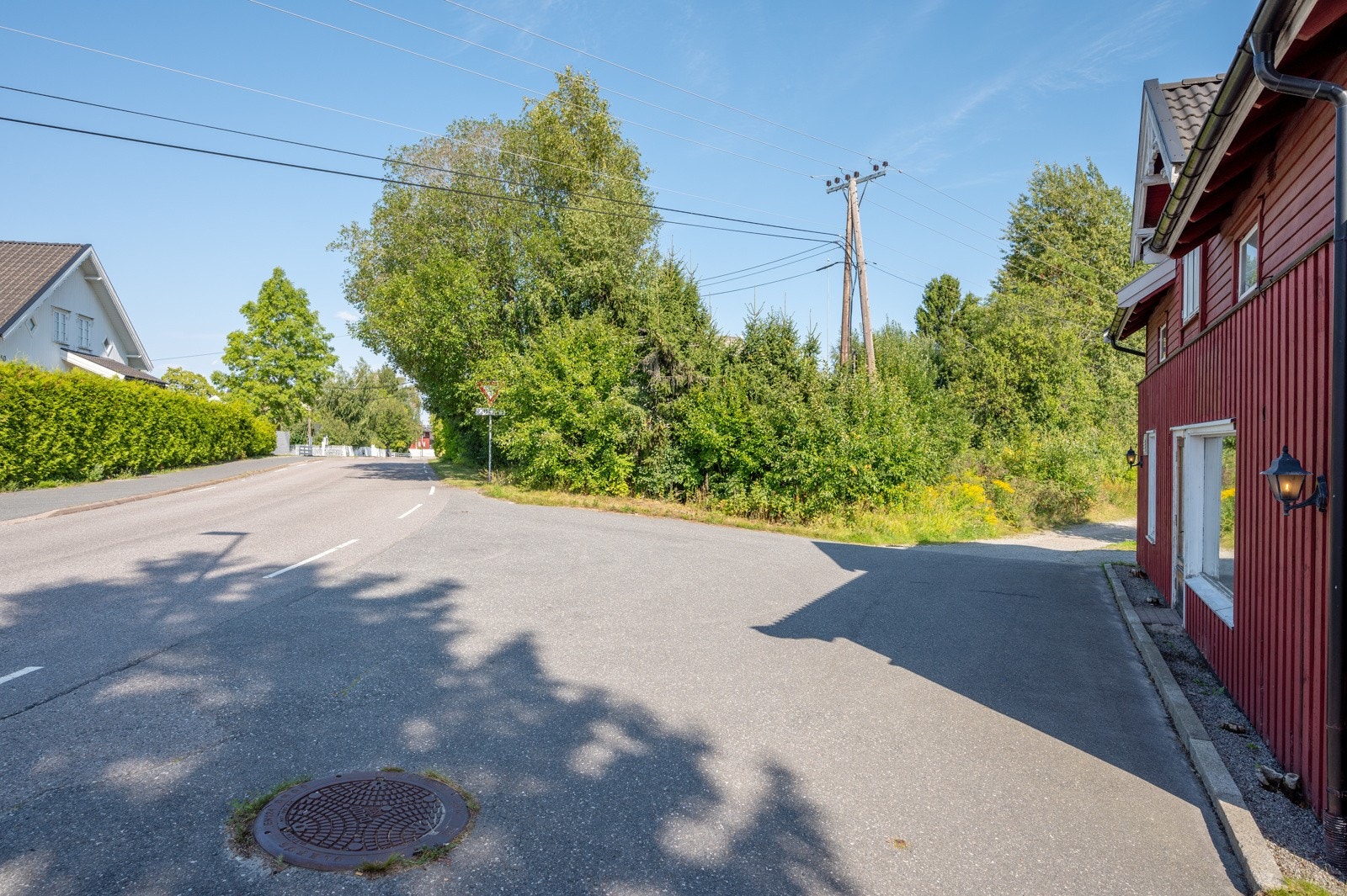 Det er asfaltert parkeringsareal foran butikklokalet og gruset parkering på siden. Galleribilde