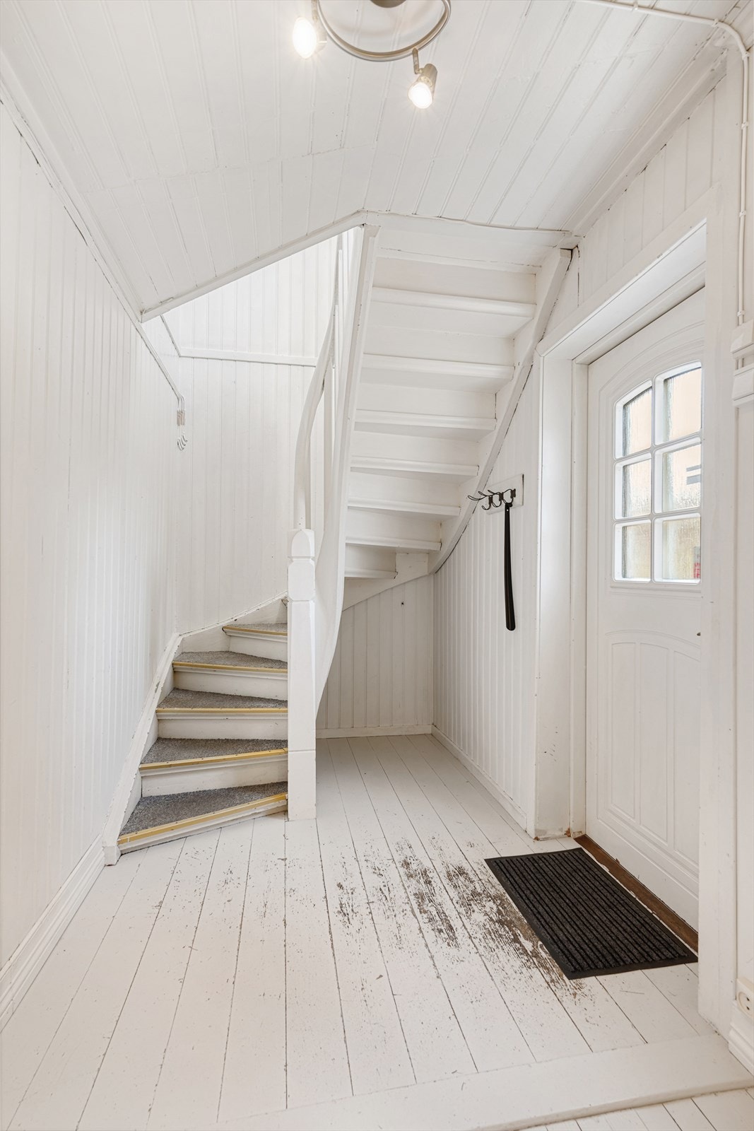 Leiligheten har egen inngang i første etasje til en lysmalt gang med trapp opp til andre etasje. Galleribilde