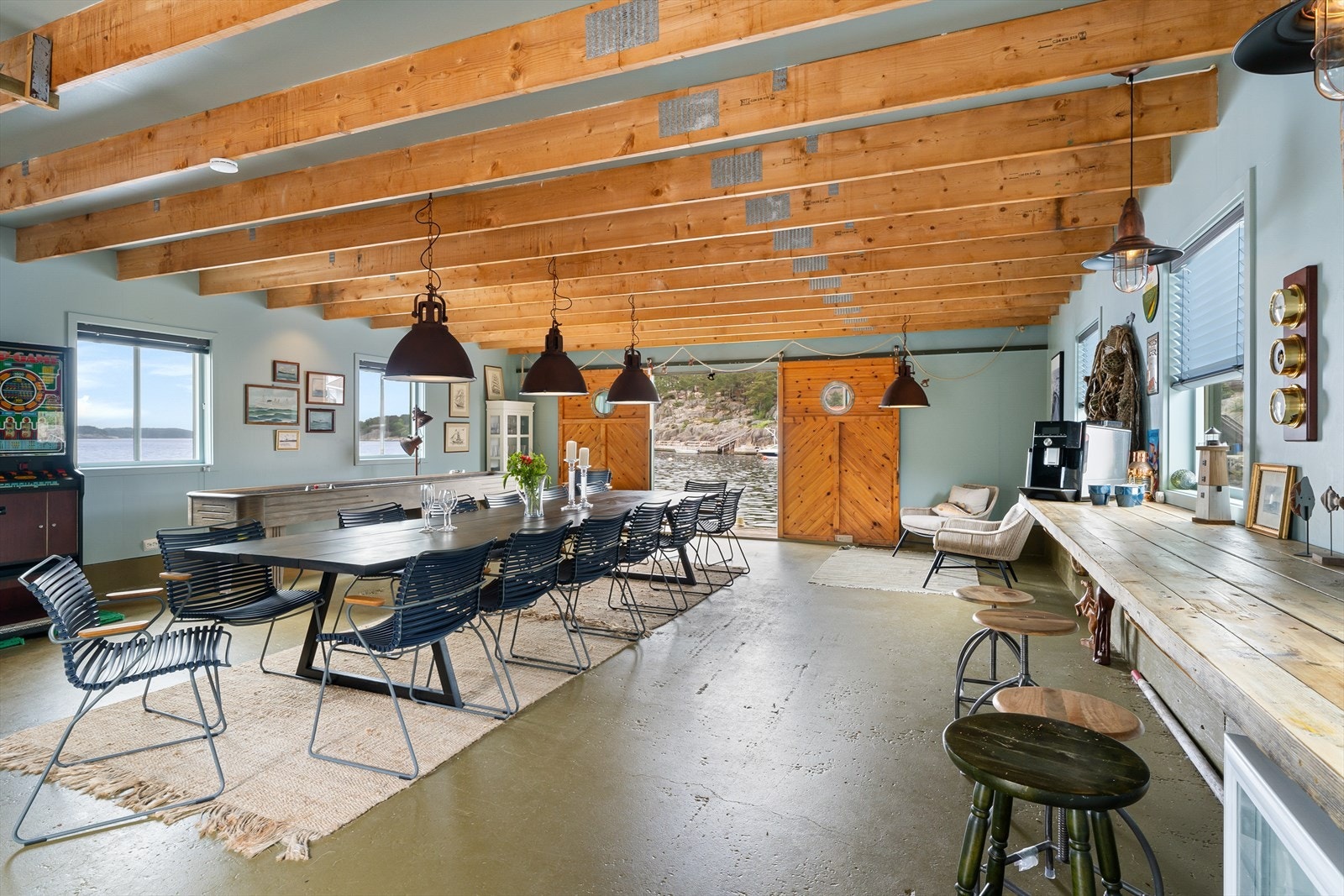 Sjøhuset er innredet for sosiale sammenkomster med spisebord og shuffleboard Galleribilde