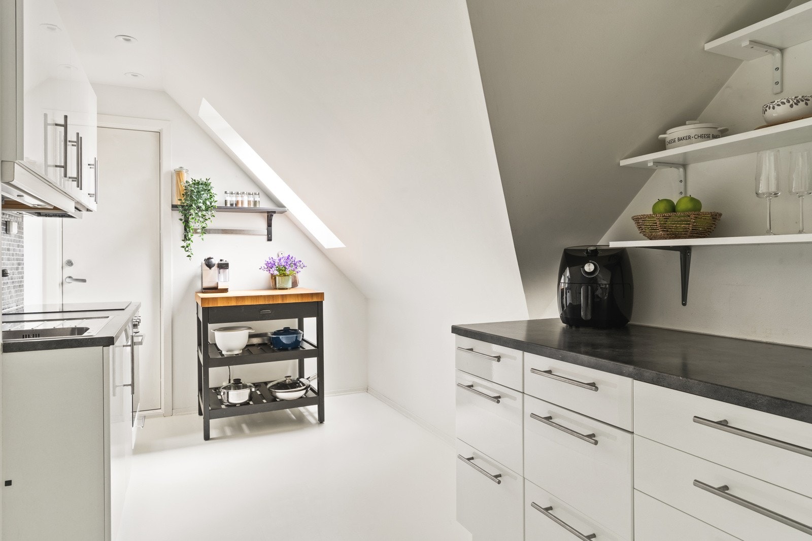 Kjøkkeninnredning er med slette hvite fronter og laminat benkeplate med nedfelt vask av stål. Galleribilde