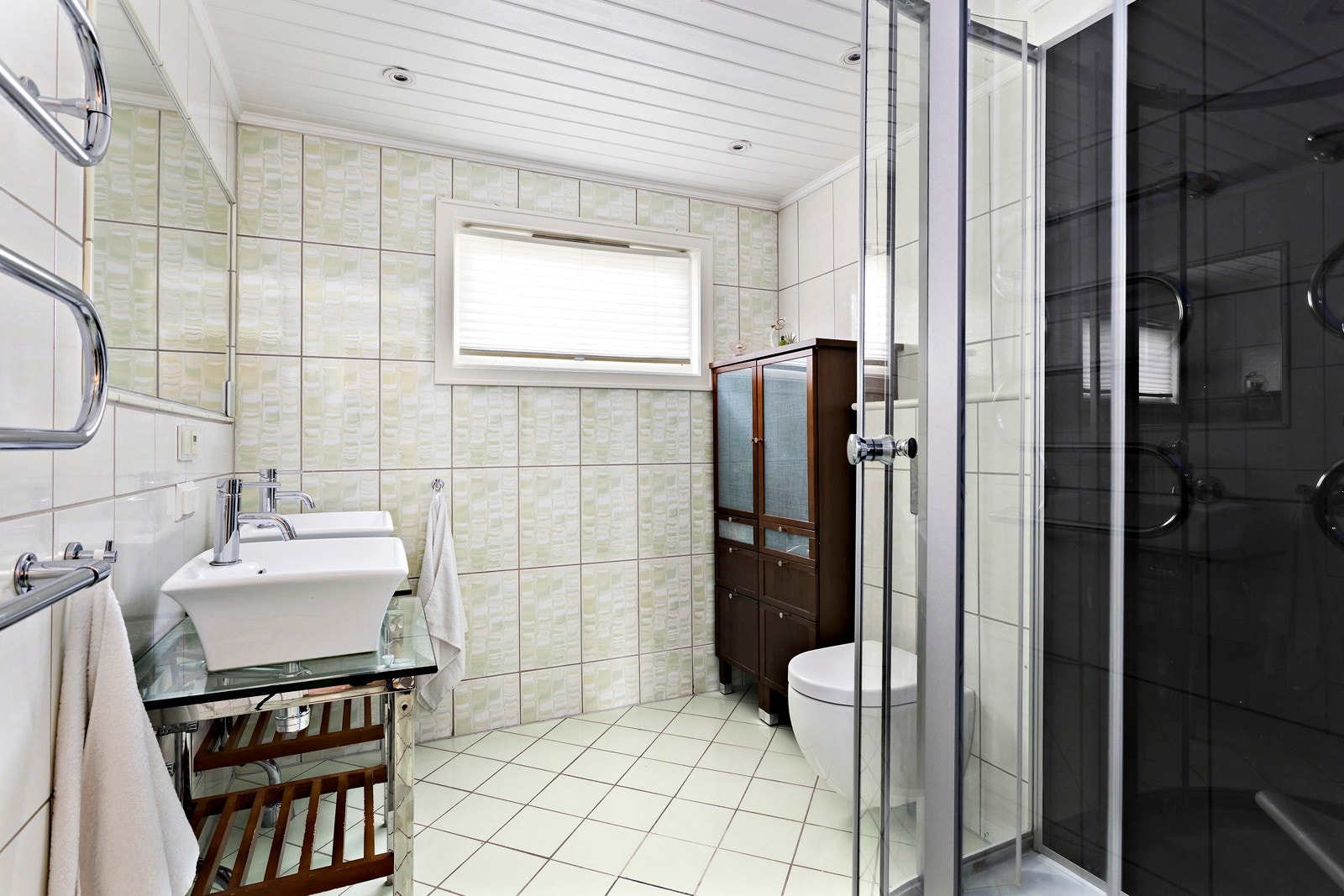 Praktisk og pent helflislagt bad som ligger i tilknytning til soverommene. Over servanten er det en høyttaler. Her kan man pusse tenner og lytte til radio tidlig om morgen. Galleribilde