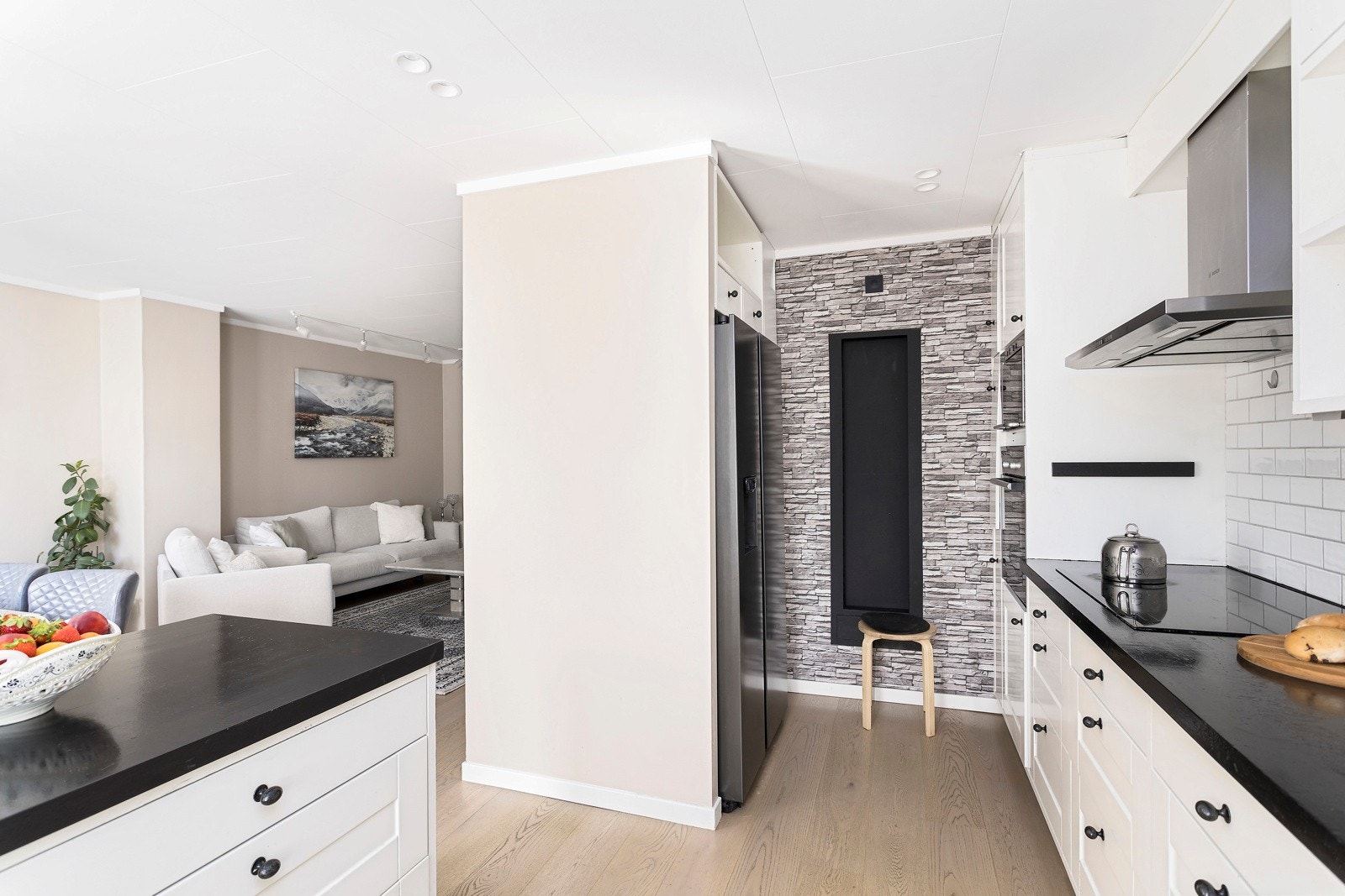 Kjøkkeninnredningen består av integrerte hvitevarer, komfyr og mikroovn i høyskap, nedfelt platetopp og oppvaskmaskin i benk. Galleribilde