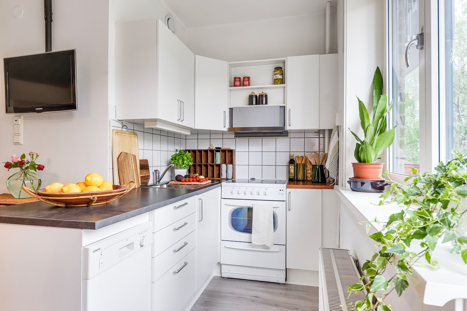 Kjøkkenet er innredet med slette, hvite fronter, laminert benkeplate og frittstående hvitevarer. Kjøleskap, komfyr og oppvaskmaskin (delvis innebygget) følger leiligheten. Galleribilde