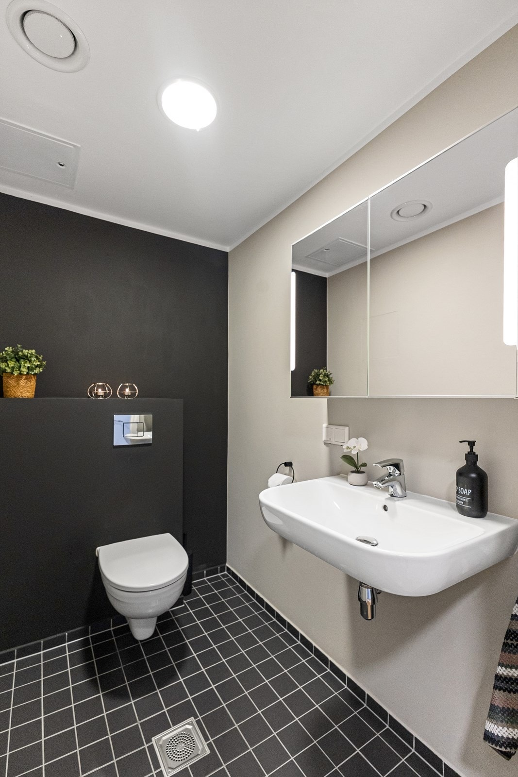 Wc-rom med speilskap med innfelt LED belysning. Fliser på gulv. Galleribilde