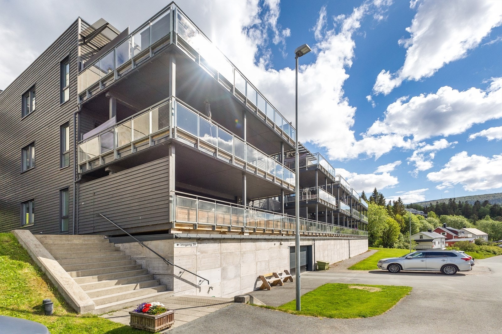 Mot fasade. Leiligheten ligger på hjørnet helt øverst på venstre hånd. Innkjørsel til felles garasjeanlegg kan sees på midtre del av u.etg. Galleribilde