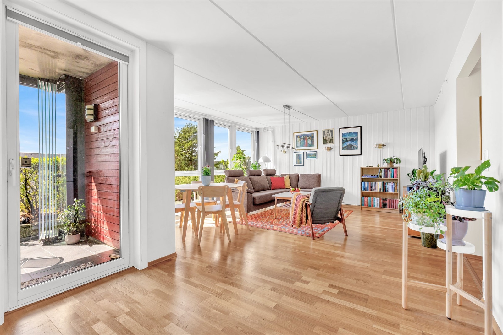 Romslig stue med store vindusflater. Diverse medfølgende løsninger for solskjerming er montert. Galleribilde