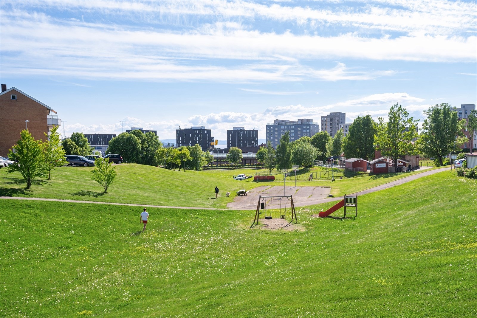 Balkongen vender ut mot rolige fellesområder. Rekreasjonsmuligheter for store og små i Nordre Åsen borettslag. Galleribilde