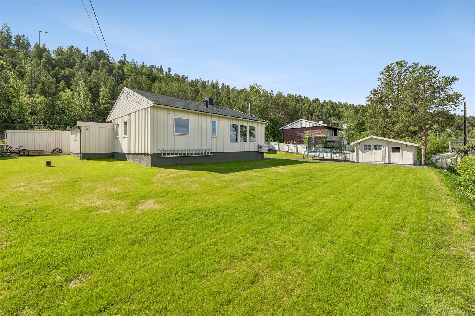 Eiendom av god størrelse med plen, terrasse og knust fjell i innkjøringen. Galleribilde