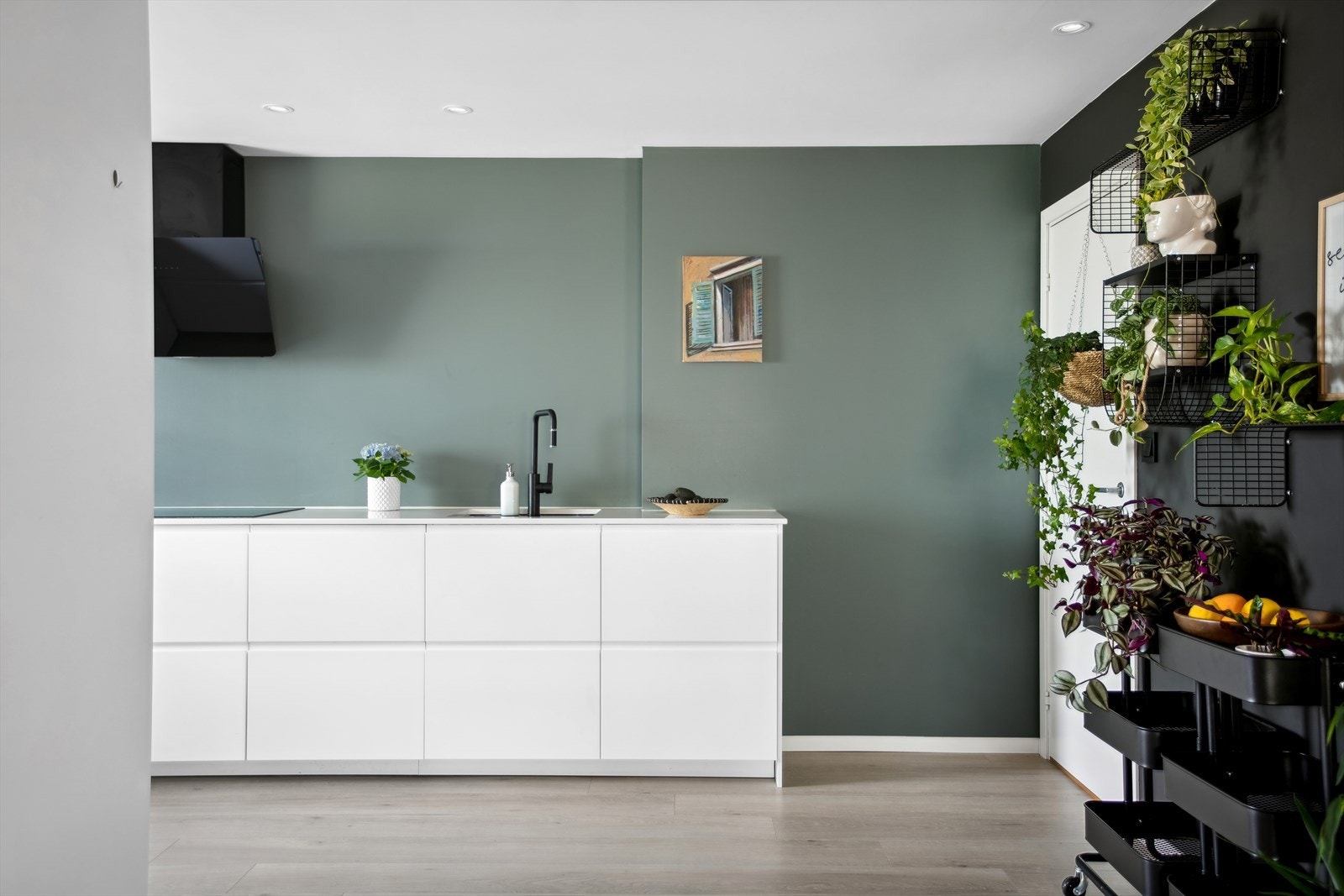 Stilrent kjøkken fra 2019 som løfter frem sorte detaljer, slik som ventilasjonen og underlimt vask. Galleribilde