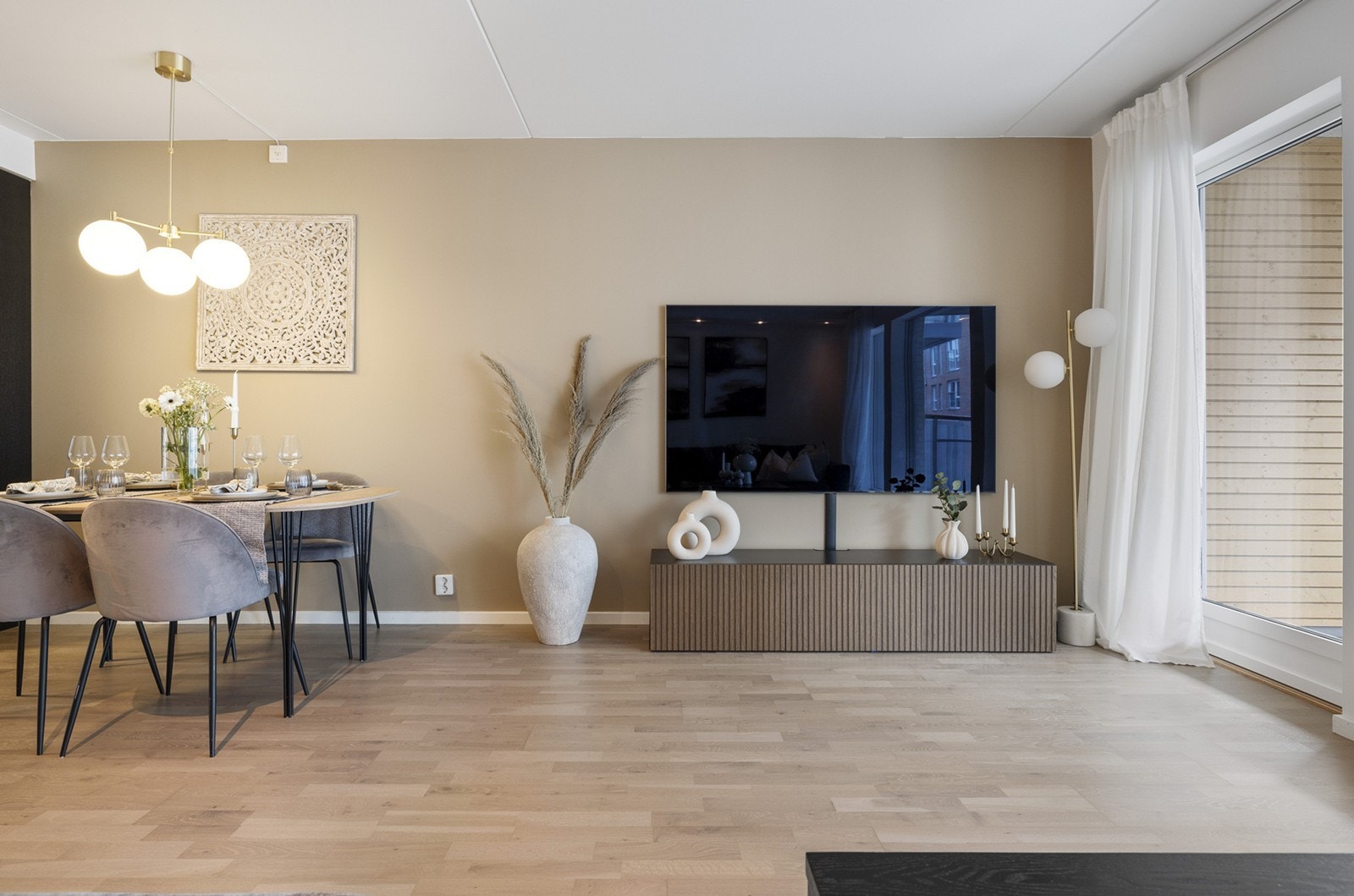 Det er fin utforming for sofagruppe og mediemøblement i egen sone, samt spisebord i praktisk tilknytning til kjøkkenet. Galleribilde
