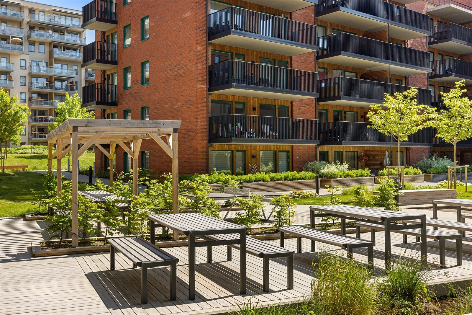 Uteområdet er opparbeidet med sittebenker, pergola, beplantning og lekeplass for de minste. Galleribilde