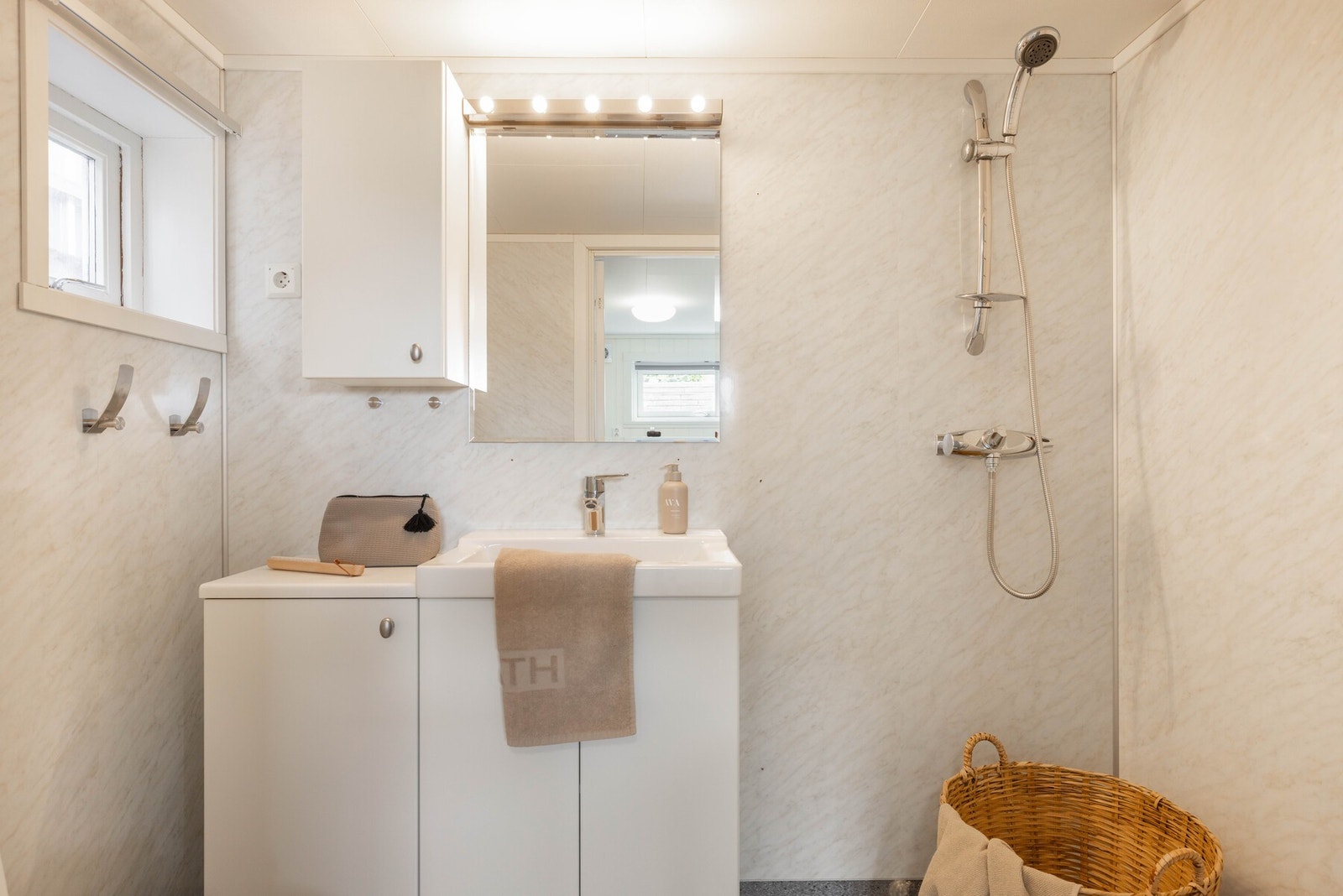 Badet er innredet i lyse farger og har tidløst baderomsmøblement i hvitt Galleribilde