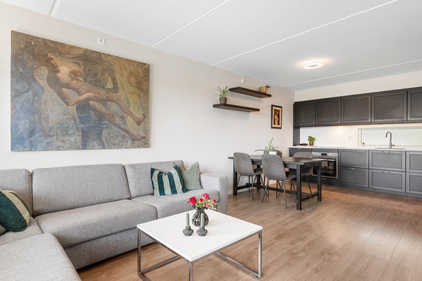 Åpen stue- kjøkken løsning med profilerte sorte fronter. Galleribilde