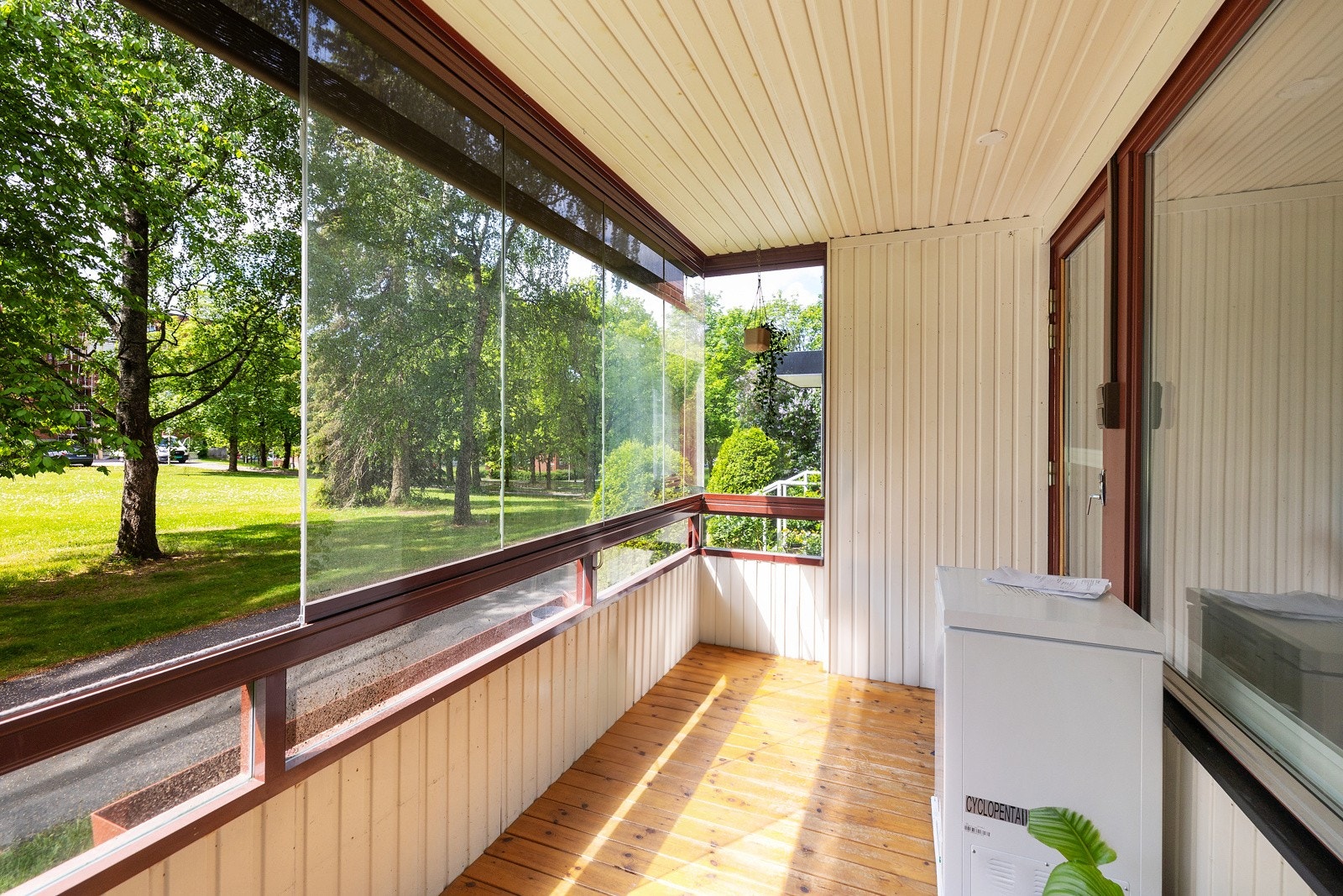 Fint utsyn mot fellesområdet med plen, trær og sittegrupper. Galleribilde