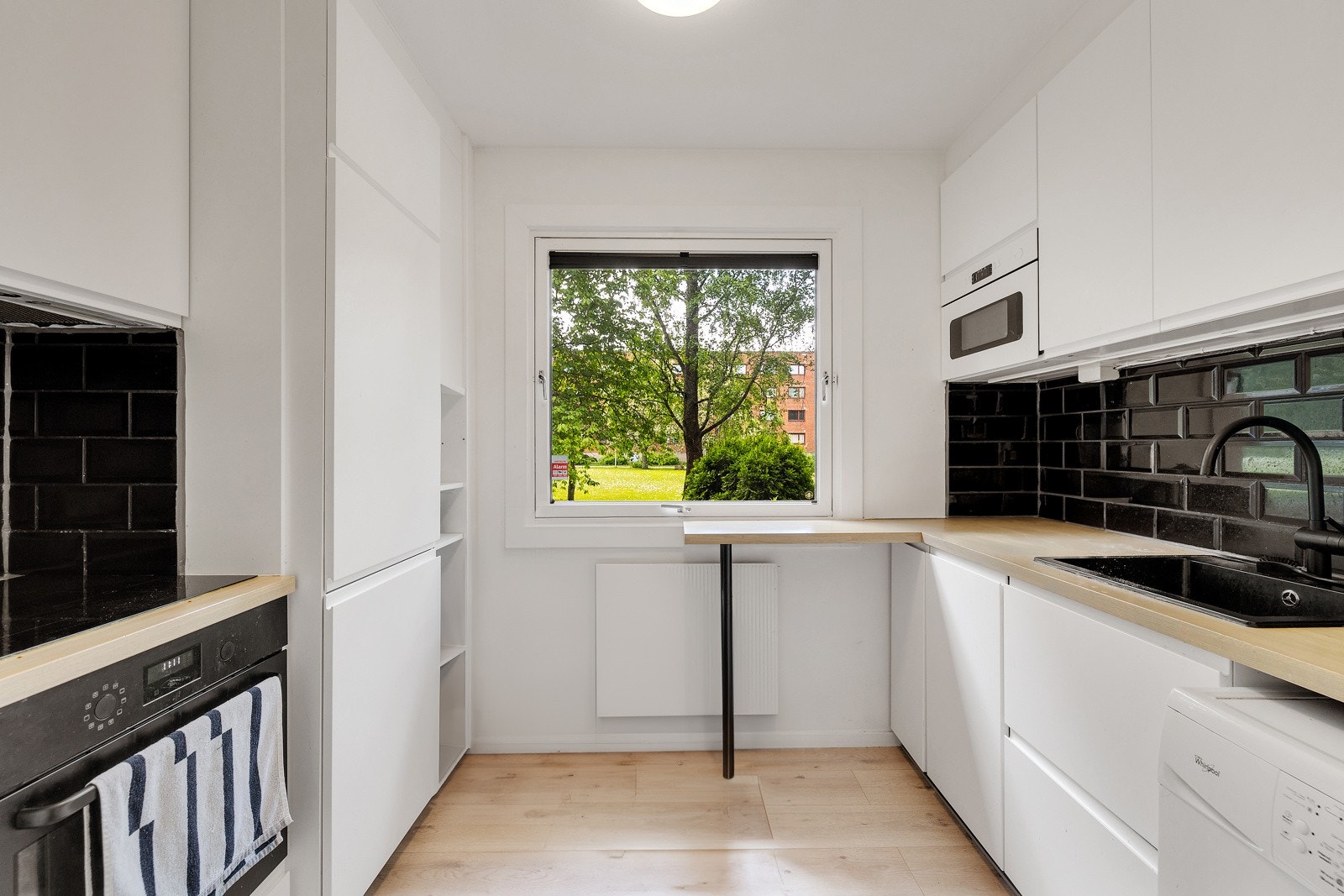 Koselig spiseplass ved vindu, komfyr, avtrekk og innebygd mikrobølgeovn. Galleribilde