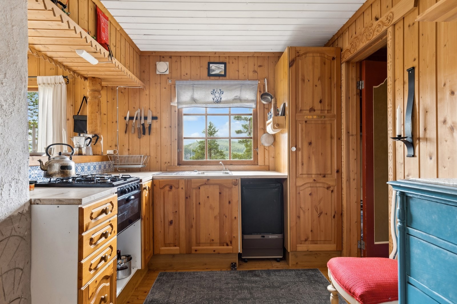 Kjøkkenet er utstyrt med vaskekum og integrert gasskomfyr. Gassbeholderen er plassert i kjøkkenbenken. Galleribilde