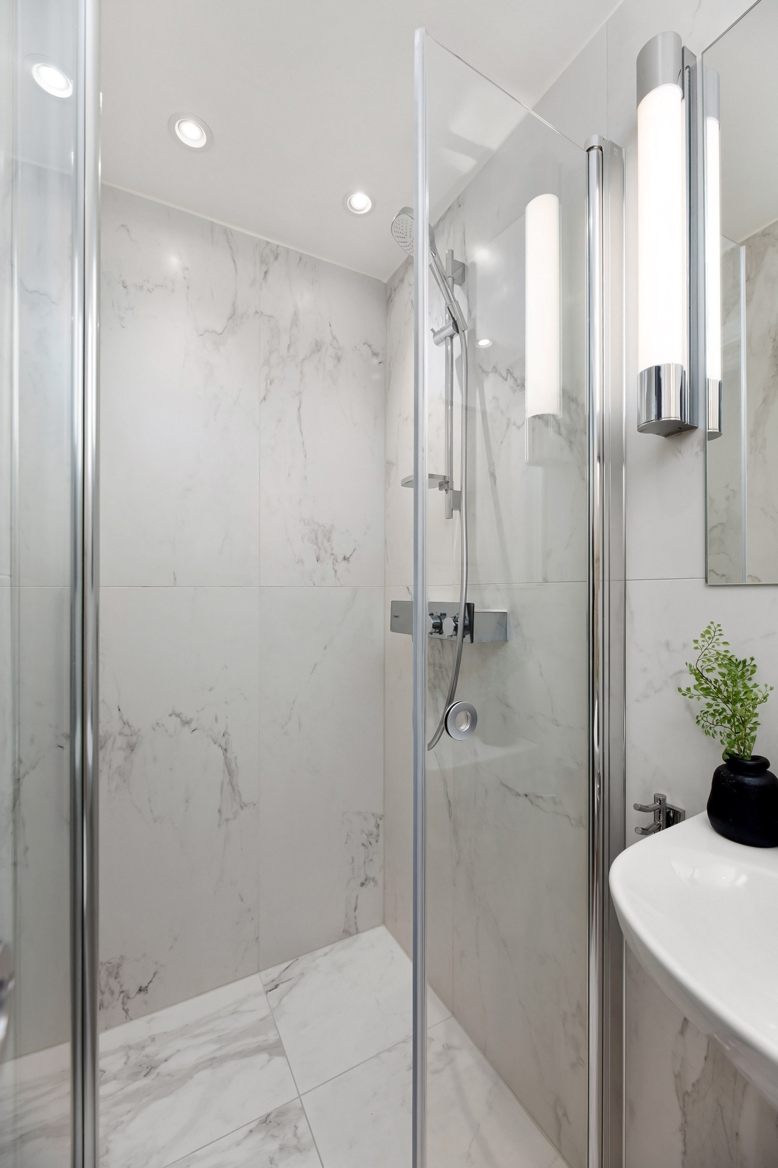 Badet er innredet med dusj, servant med overskap og toalett. Varme i gulv Galleribilde