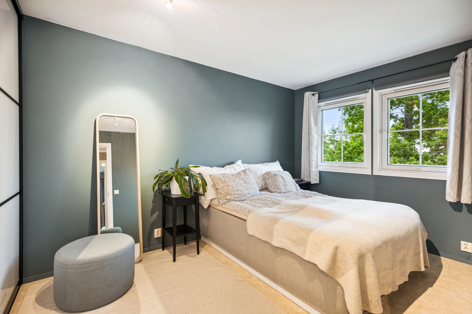 Lyst og pent hovedsoverom med moderne fargevalg, og god plass til dobbeltseng med tilhørende nattbord Galleribilde