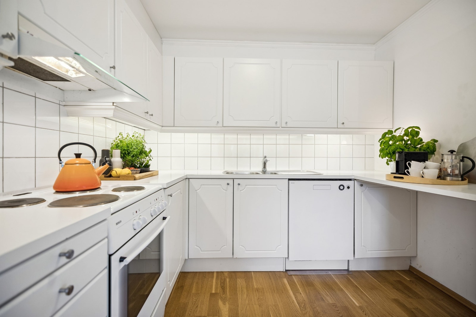 Kjøkkenet har hvite profilerte fronter og laminat benkeplate Galleribilde