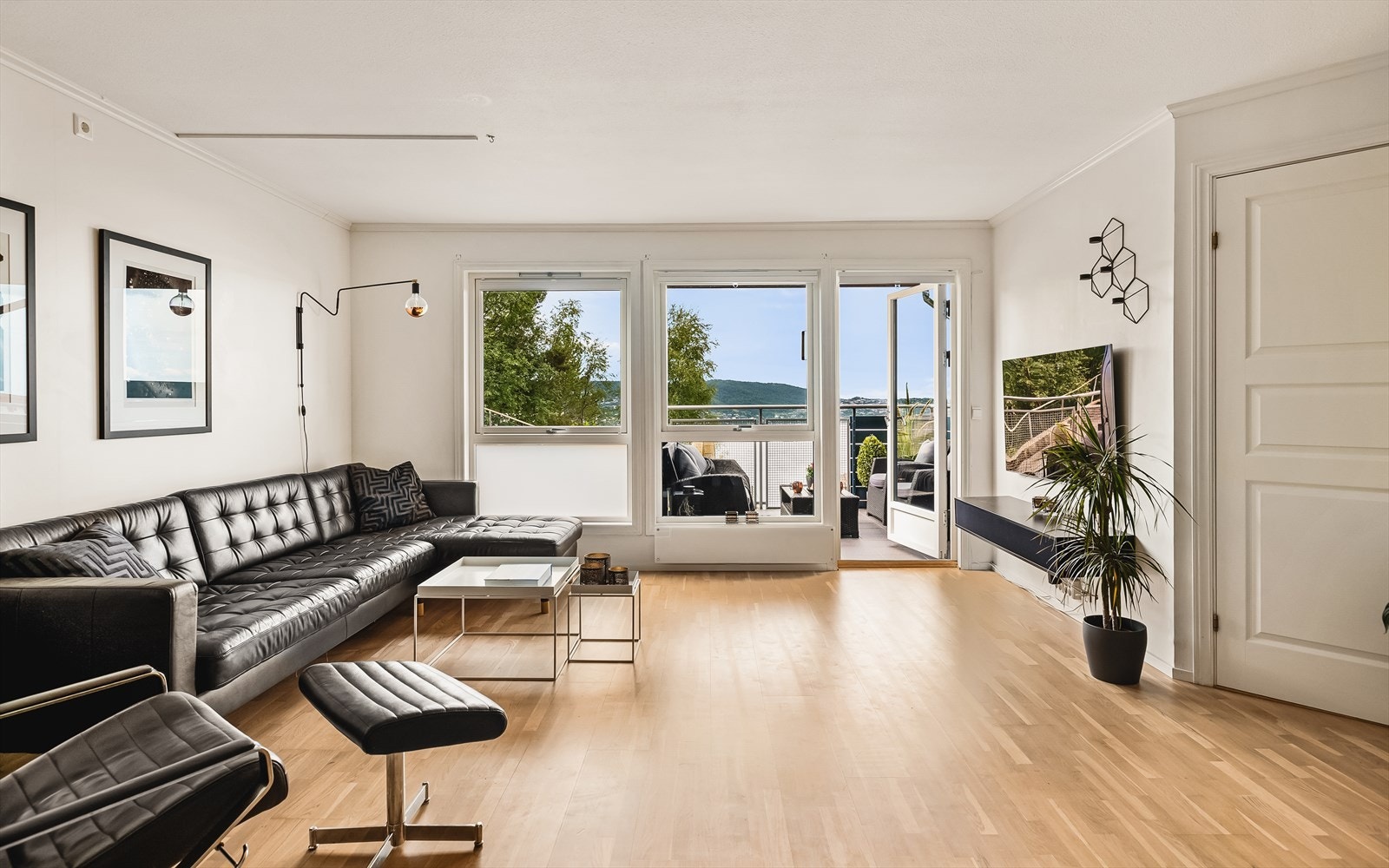 Stuen er lys og lekker, noe som gjør det enkelt å kombinere med interiør og tekstiler. Store vinduer gir mye naturlig lysinnslipp, og bidrar til å skape en herlig atmosfære i rommet Galleribilde