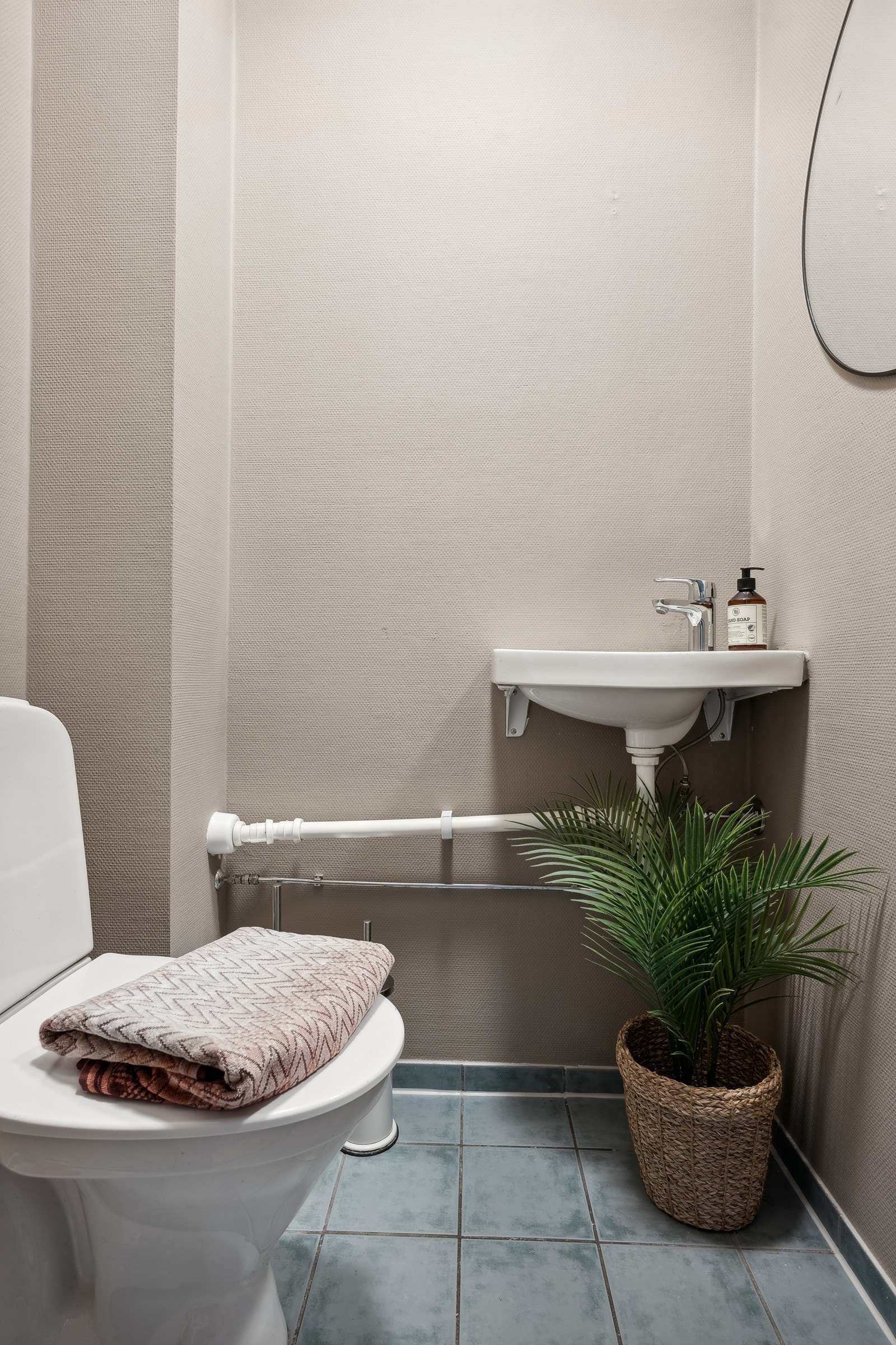 Toalettrom med flislagt gulv med gulvvarme. Vegghengt servant. Galleribilde