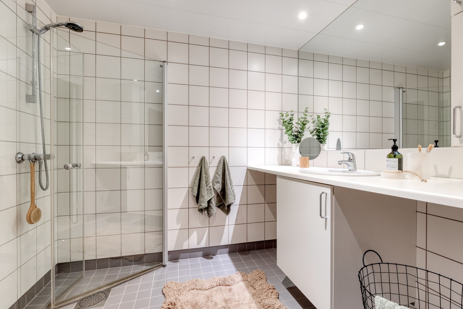 Lyst, flislagt bad med varme i gulv og downlights i himling. Galleribilde