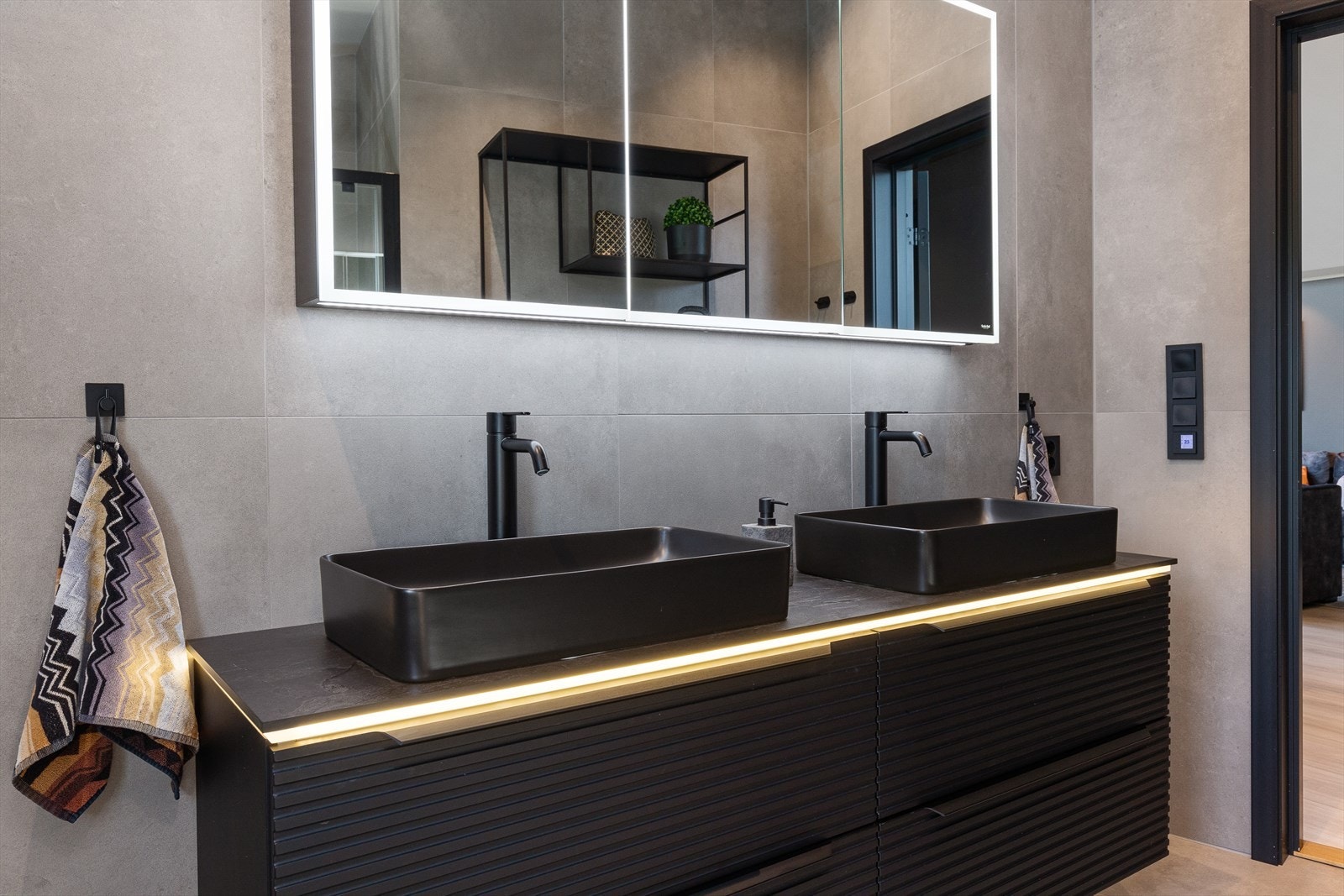 På badet er det to vaskeservanter, veggmontert wc og dusjnisje med glassdører. Galleribilde