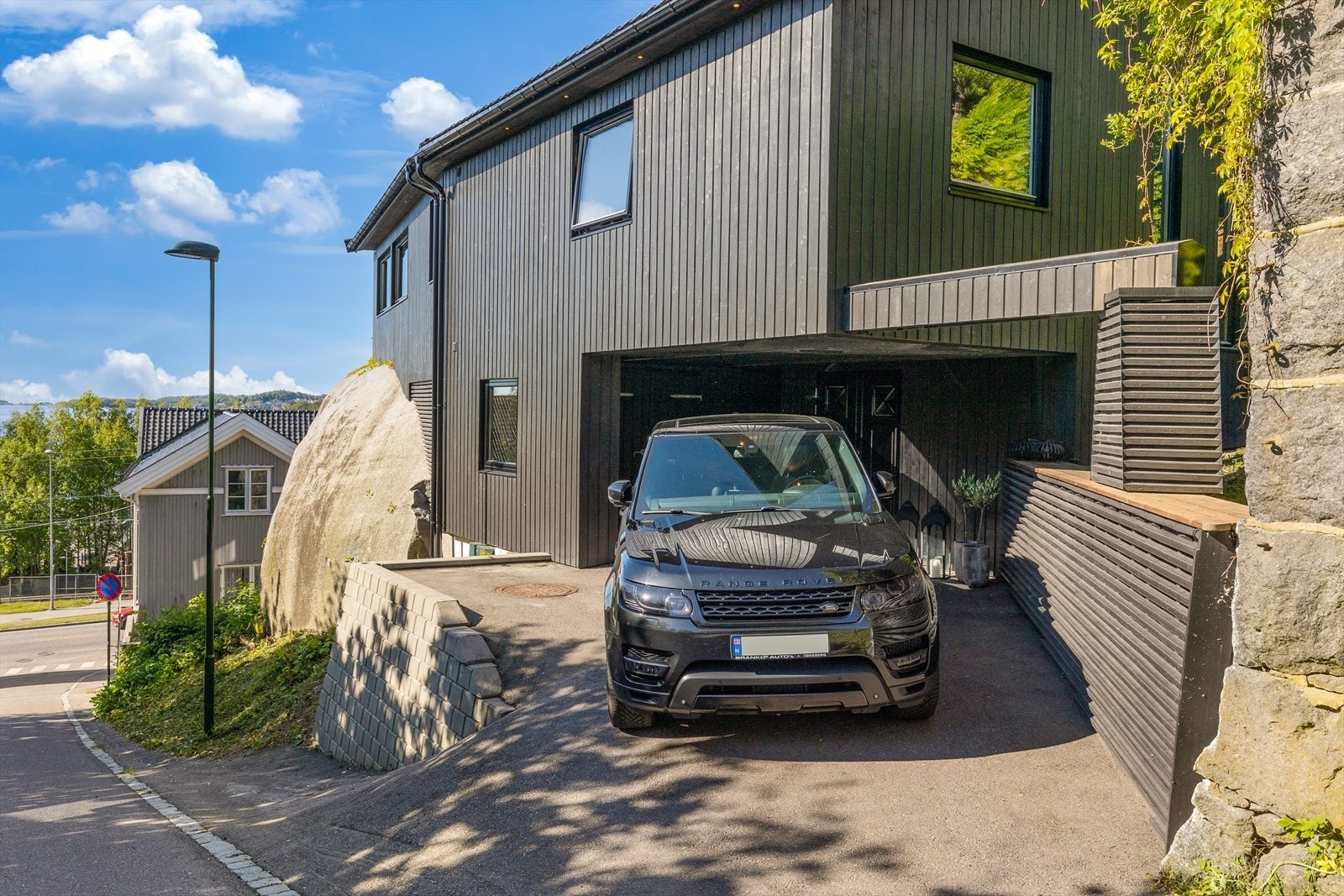 Parkering på tomten. Det er en sportsbod til venstre for inngangsparti. Galleribilde