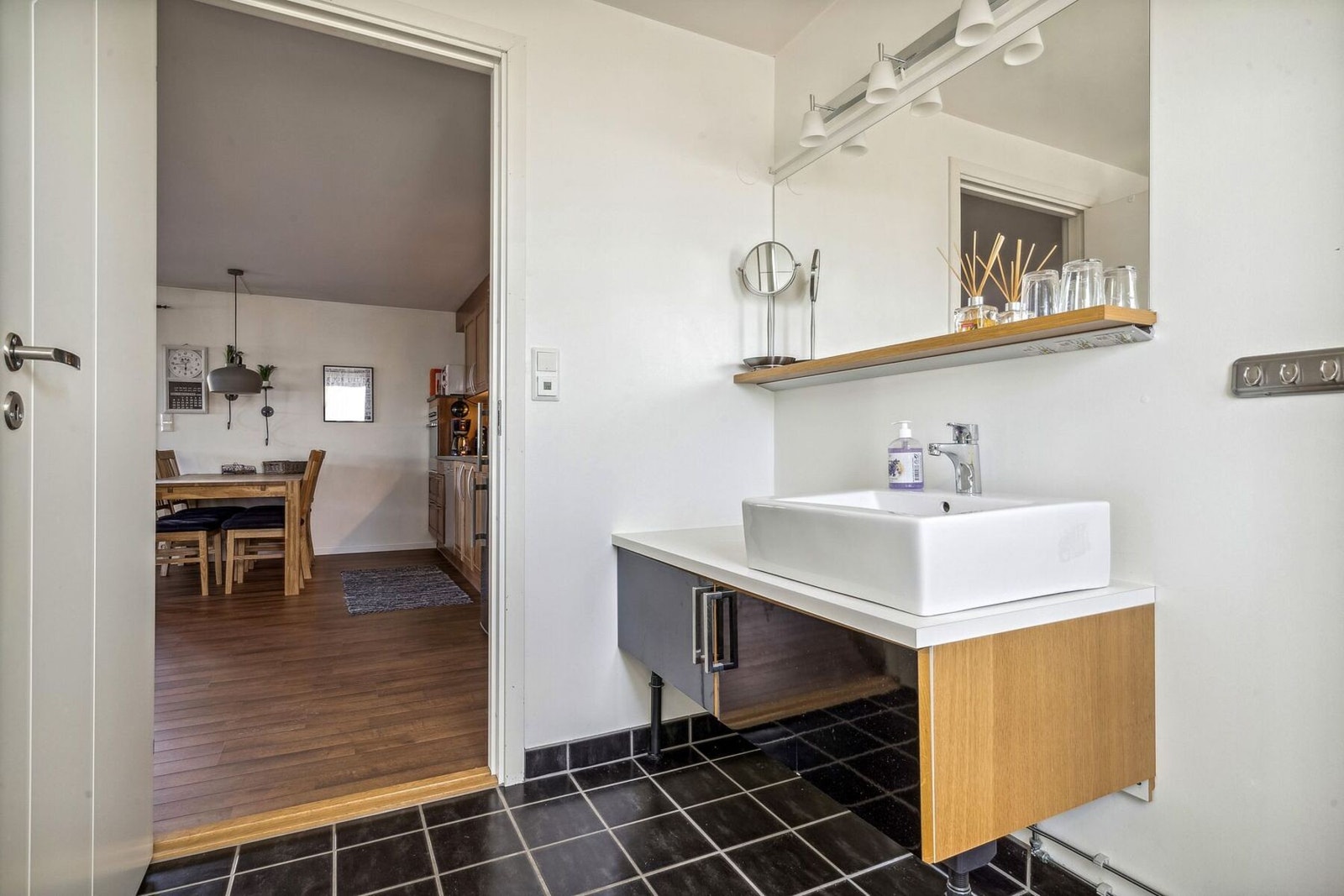 Badet har flisbelagt gulv med varmekabler. Lagringsplass i innredningen. Galleribilde