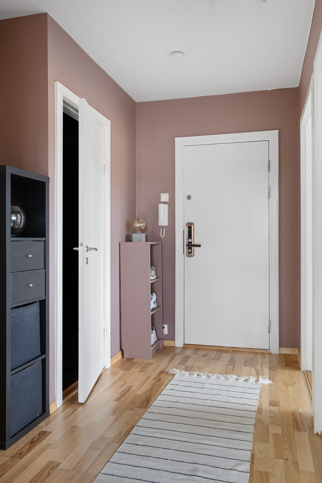 Entréen har slette overflater, dørcalling og adkomst til en bod med plass til å henge fra seg yttertøy og sette fra seg sko. Galleribilde