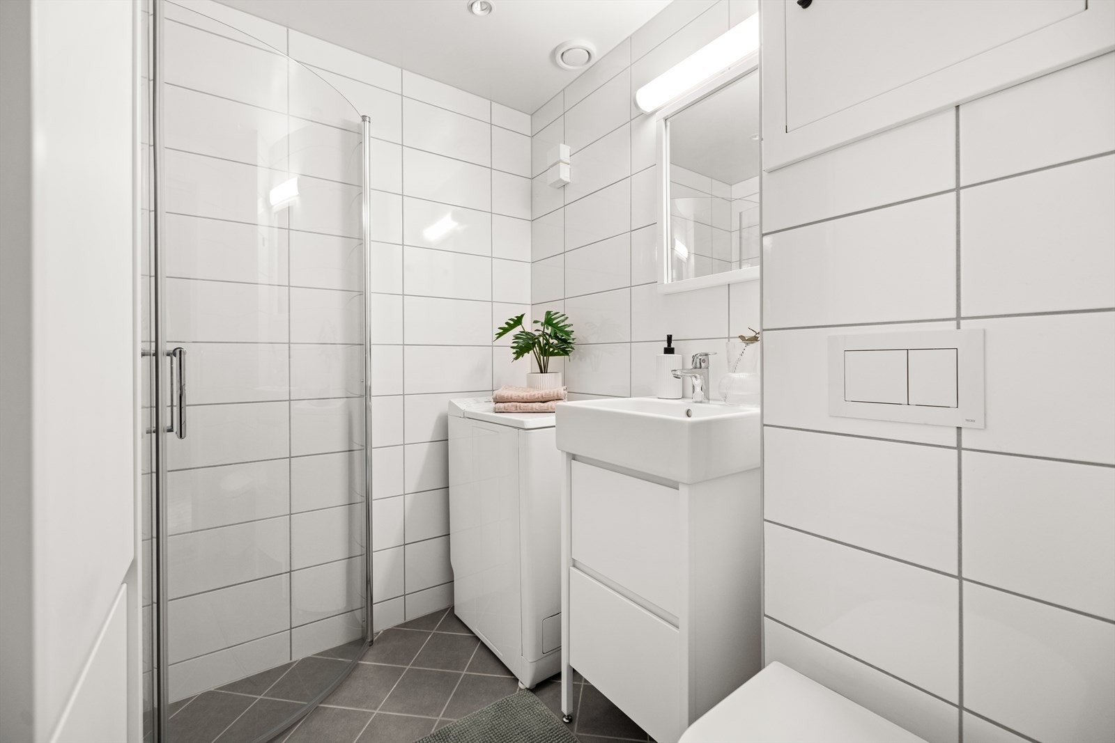 Lyst flislagt baderom med innfelt downlights og elektrisk gulvvarme. Galleribilde
